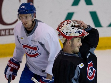 Montreal Canadiens goalie Dustin Tokarski, right, takes a break on Thursday November 27, 2014 as Montreal Canadiens left wing Jiri Sekac skates through the goal crease during a team practice at the Bell Sports Complex  in Montreal .