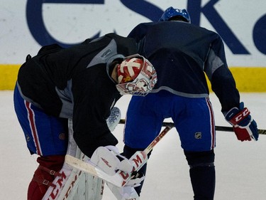 Montreal Canadiens goalie Carey Price, left, plays a prank on Montreal Canadiens defenseman Mike Weaver during a team practice at the Bell Sports Complex  in Montreal on Thursday November 27, 2014. Price upended Weaver by flipping him over with his stick leveraged against Weaver's stick.