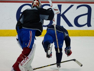 Montreal Canadiens goalie Carey Price, left, plays a prank on Montreal Canadiens defenseman Mike Weaver during a team practice at the Bell Sports Complex  in Montreal on Thursday November 27, 2014. Price upended Weaver by flipping him over with his stick leveraged against Weaver's stick.