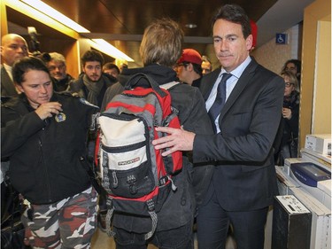 Pierre Karl Péladeau squeezes by a protester who tries to block his path as he leaves a speech to students at Université de Montréal Thursday November 27, 2014.