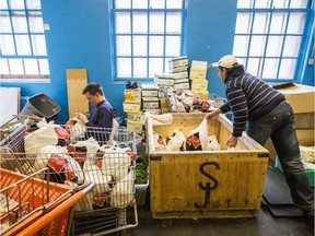 Sun Youth volunteer Nick Pfund, left, and employee Frank Hamel, right, prepare food bags at the Sun Youth food bank in Montreal on Monday, Nov. 3, 2014.