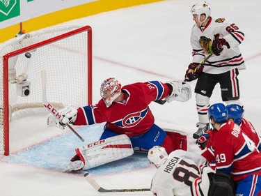 Chicago Blackhawks right wing Marian Hossa, bottom, attempts a shot against Montreal Canadiens goalie Carey Price as Chicago Blackhawks center Andrew Shaw looks on during the second period at the Bell Centre on Tuesday, Nov. 4, 2014.