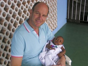 Claude Perras with his adopted daughter Ella in Sierra Leone.  Perras is unable to bring Ella to Canada because of travel ban related to the Ebola outbreak in western Africa.