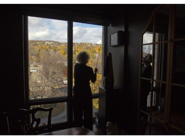 Havie Walker opens blinds to show the view from her home in Westmount.