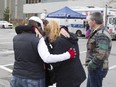 Liliane Cyr, third from left, is comforted by friends and family at a Saint-Laurent parking lot Nov. 6, 2014, after police failed to find any clues related to the disappearance in 1978 of her toddler.