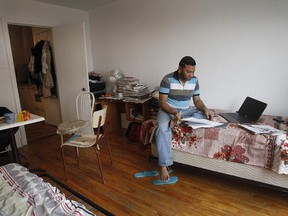 Mohammad Tofazzal Hossain uses one of his beds as a sofa while working on his computer in his tiny 2 1/2 apartment in Montreal's Mile End  districtl. He is one of those tenants who pays more than 80 per cent of his revenue on shelter. It is a growing crisis for one in ten tenants in this city.  The problem is more severe in Cote des Neiges, and it hits immigrants the hardest.