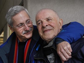 Arthur Ney, 84 years old, right, a Holocaust survivor gets a hug from his son David.