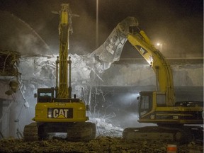 Heavy machinery works at demolishing the Highway 30 overpass over Highway 20 in Sainte-Julie late Saturday night, November 8, 2014.