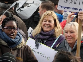 Michelle Sauvé, centre, director of the CPE Whiteside Taylor daycare, joins daycare workers and parents protesting the Quebec government's plan to cut funding to daycares at Place des Festivals in Montreal on Sunday, Nov. 9, 2014.