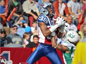 Alouettes receiver Duron Carter catches a touchdown pass over Saskatchewan Roughriders defensive- back Rod Williams during CFL game at Montreal's Molson Stadium on Oct. 13, 2014.