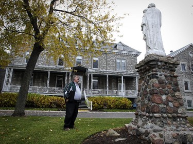 Michel Forest of the Pointe Claire Heritage Society looks up at religious statue in front of the Congrégation de Notre Dame convent in Pointe Claire.  The six remaining nuns are being relocated, leaving the fate of the property on the point in Pointe Claire village up in the air.