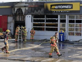 Firefighters clean up after a blaze at Autopneau, a tire shop on St-Jean Blvd. in DDO on Wednesday, Sept. 10, 2014.