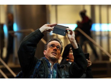 A man takes a photograph of the newly opened Fulton Center train station in lower Manhattan on November 10, 2014 in New York City.  The station was scheduled to open in 2007 as part of the rebuilding effort of lower Manhattan after 9/11, but the project ran into cost overruns and years of delays. The original plan for the facility, which has a glass and steel shell and 66,000 square feet of retail and office space, was projected at $750 million and nearly doubled to $1.4 billion before it was finished. The station features a 10-foot-high glass opening , or oculus, which sits above an atrium that lets sunlight down into two levels below street level. The station makes it easier to connect between nine subway lines: the A, C, J, Z, R, 2, 3, 4, and 5. Riders will eventually also be able to connect to the E and 1 trains, as well as the PATH.