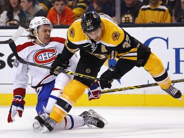 Montreal Canadiens' P.A. Parenteau, left, is checked by Boston Bruins' Patrice Bergeron during the first period of an NHL hockey game in Boston, Saturday, Nov. 22, 2014.