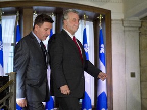 Quebec Premier Philippe Couillard and Quebec Municipal Affairs Minister Pierre Moreau, left, arrive at a news conference to announce an agreement with municipalities, Wednesday, November 5, 2014 at the legislature in Quebec City.