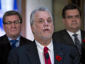Quebec Premier Philippe Couillard, flanked by Quebec City Mayor Regis Labeaume, left, and Montreal Mayor Denis Coderre, announces an agreement with municipalities, Wednesday, November 5, 2014 at the legislature in Quebec City.