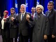 Quebec Premier Philippe Couillard, center, poses for photos with members of the Muslim community after their meeting Monday, Nov. 17, 2014 in Montreal.