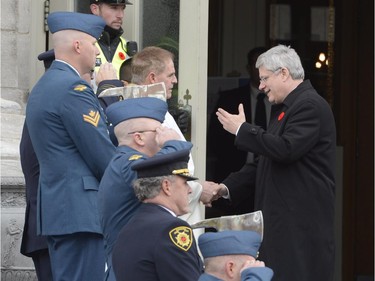 Prime Minister Harper, right, shakes hands on his arrival at a cathedral in Longueuil, Saturday, Nov. 1, 2014, for the funeral for warrant officer Patrice Vincent, who died after being hit by a car driven by an attacker with known jihadist sympathies. The 53-year-old Vincent was killed on Oct. 20 in the parking lot of a shopping mall in Saint-Jean-sur-Richelieu, southeast of Montreal.