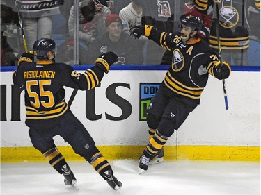 Buffalo Sabres' Rasmus Ristolainen (55) celebrates the game-winning goal by Matt Moulson (26) in front of their fans during the third period of an NHL hockey game against the Montreal Canadiens Friday, Nov. 28, 2014, in Buffalo, N.Y.  Buffalo won 2-1.