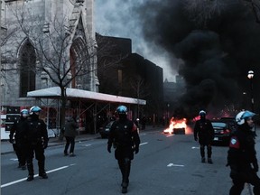 Police scatter a small crowd after a garbage and some tires were set on fire in downtown Montreal.
