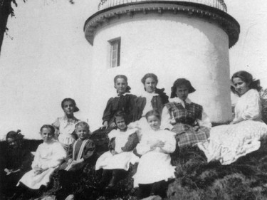 Students from the convent of the Soeurs de la Congregation de Notre-Dame de Pointe-Claire sitting in front of the windmill at The Point, circa 1910.