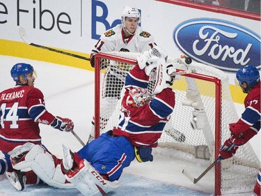 Carey Price makes a save against Chicago Blackhawks' Jeremy Morin as Canadiens' Tomas Plekanec (14) and Tom Gilbert look for the rebound during first- period action in Montreal, Tuesday, Nov. 4, 2014.