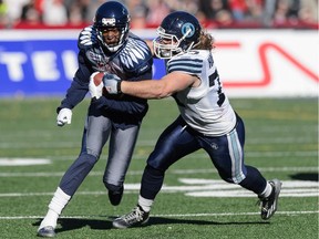 Logan Harrell #77 of the Toronto Argonauts tackles Duron Carter #89 of the Montreal Alouettes during the CFL game at Percival Molson Stadium on Nov. 2, 2014 in Montreal.