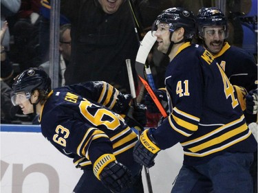 Buffalo Sabres centre Tyler Ennis (63) celebrates his first-period goal with Andrej Meszaros (41) and Matt Moulson (26) against the Montreal Canadiens in an NHL hockey game Friday, Nov. 28, 2014, in Buffalo, N.Y. Buffalo won 2-1.
