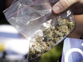 A man pulls out a bag of marijuana to fill a pipe at the first day of Hempfest, in Seattle in 2013.