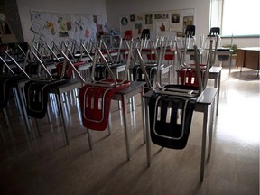 A vacant teachers desk is pictured at the front of a empty classroom.