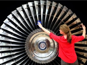 A woman cleans a Stage 1 Pratt and Whitney jet engine turbine dating from around 1970, at the Fine Art and Antiques Fair in London, on June 8, 2011.