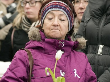 A woman takes part in a ceremony at the memorial park to mark the 25th anniversary of the Polytechnique massacre Saturday, December 6, 2014 in Montreal. It was 25 years ago Saturday that a gunman shot and killed 14 women before taking his own life at the École Poytechnique of the Université de Montréal.