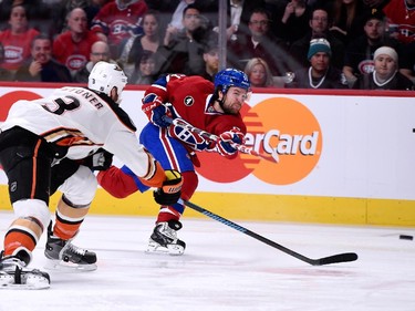 David Desharnais (#51) of the Montreal Canadiens shoots the puck in front of Clayton Stoner (#3) of the Anaheim Ducks during the NHL game at the Bell Centre on December 18, 2014 in Montreal.