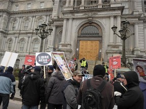 People gather in protest against the government in front of the Montreal city hall on November 26, 2014.