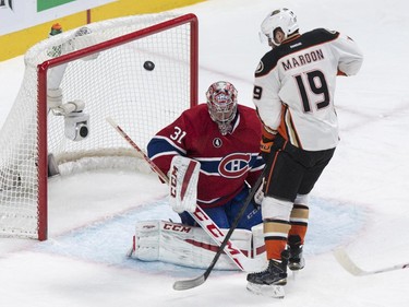 The puck flies away as Montreal Canadiens goalie Carey Price makes a save off Anaheim Ducks' Patrick Maroon during second period NHL hockey action Thursday, December 18, 2014 in Montreal.
