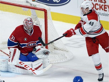 Montreal Canadiens goalie Carey Price (31) makes the save as Carolina Hurricanes centre Victor Rask (49) swings at the loose puck during first period National Hockey League action Tuesday, December 16, 2014 in Montreal.