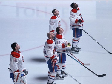 Montreal Canadiens goalie Carey Price (31) and teammates watch as a tribute to hockey legend Jean Béliveau plays before the first period of an NHL hockey game against the Minnesota Wild in St. Paul, Minn., Wednesday, Dec. 3, 2014.