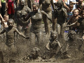 Children run into the mud in Westland, Mich., Tuesday, July 9, 2013. Hundreds of kids enjoyed the annual Mud Day event in the 7-by-150-foot mud pit.