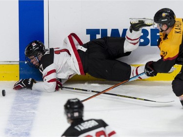 Team Canada's Connor McDavid is tripped by Team Germany's Dominik Kahun during first period preliminary round hockey action at the IIHF World Junior Championship Saturday, December 27, 2014 in Montreal.