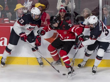 Canada's Curtis Lazar tries to control the puck away from USA's Zach Werenski, left, and Auston Matthews during first period preliminary round hockey action at the IIHF World Junior Championship, Wednesday, December 31, 2014 in Montreal.