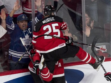 Canada's Darnell Nurse leaps on teammate Max Domi celebrating Domi's goal against the USA during second period preliminary round hockey action at the IIHF World Junior Championship Wednesday, December 31, 2014 in Montreal.