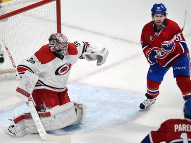 Montreal Canadiens centre David Desharnais (51) goes after a loose puck as Carolina Hurricanes goalie Cam Ward (30) looks on during first period National Hockey League action Tuesday, December 16, 2014 in Montreal.