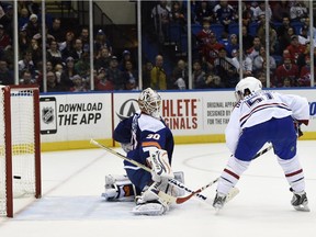 Montreal Canadiens center David Desharnais (51) shoots the puck past New York Islanders goalie Chad Johnson (30) to score during the third period of an NHL hockey game at Nassau Coliseum on Tuesday, Dec. 23, 2014, in Uniondale, N.Y. The Canadiens won 3-1.