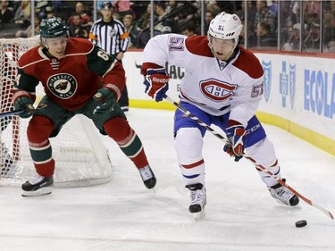 Montreal Canadiens centre David Desharnais (51) controls the puck in front of Minnesota Wild centre Mikael Granlund, centre, of Finland, and Wild goalie Darcy Kuemper, left,  during the second period of an NHL hockey game in St. Paul, Minn., Wednesday, Dec. 3, 2014.