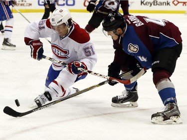 Montreal Canadiens centre David Desharnais, left, battles for control of the puck with Colorado Avalanche defenceman Tyson Barrie in the first period of an NHL hockey game in Denver on Monday, Dec. 1, 2014.