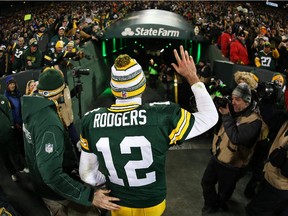 Packers quarterback Aaron Rodgers waves to fans as he walks off of the field after defeating the Detroit Lions 30-20 to take the NFC North Championship at Lambeau Field on Dec. 28, 2014 in Green Bay, Wisconsin.