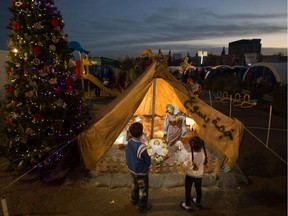 Iraqi Christian children look at a nativity scene that is displayed in a tent erected in the grounds of Mazar Mar Eillia Catholic Church, in Ankawa, that has now become home to hundreds of Iraqi Christians who were forced to flee their homes as the Islamic State advanced earlier this year, on December 12, 2014 in Erbil, Iraq.