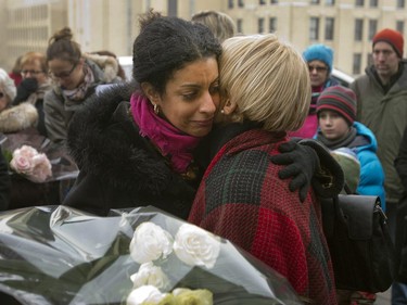 Dominique Anglade, left, is comforted by Michele Thibodeau DeGuire, president and principal of Ecole Poytechnique, during a ceremony at the memorial plaque to mark the 25th anniversary of the Polytechnique massacre Saturday, December 6, 2014 in Montreal. It was 25 years ago Saturday that a gunman shot and killed 14 women before taking his own life at the École Poytechnique of the Université de Montréal.