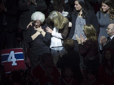Élise Béliveau is consoled by her daughter Hélène as she is overcome by emotion as she stands next to her husband Montreal Canadiens legend Jean Béliveau's empty seat, during a ceremony prior to facing the Vancouver Canucks in NHL hockey action Tuesday, December 9, 2014 in Montreal. Béliveau died last week at the age of 83.