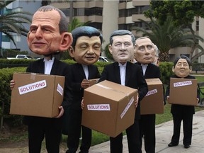 Environmental activists represent, from left, Australia's Prime Minister Tony Abbott, China's President Xi Jinping, Canada's Prime Minister Stephen Harper, Russia's President Vladimir Putin and Japan's Prime Minister Shinzo Abe during the Climate Change Conference COP20, in Lima, Dec. 12, 2014.